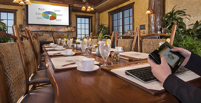 Set table with business pads, pens and audio-visual presentation.